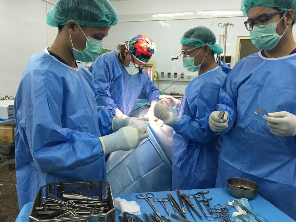 上顎多形成腺腫の手術の様子。ラオス大学口腔外科マスターコースの若手たちが、岩田さんを囲んで熱心に術式を覚える（写真提供：ウィズアウトボーダー）