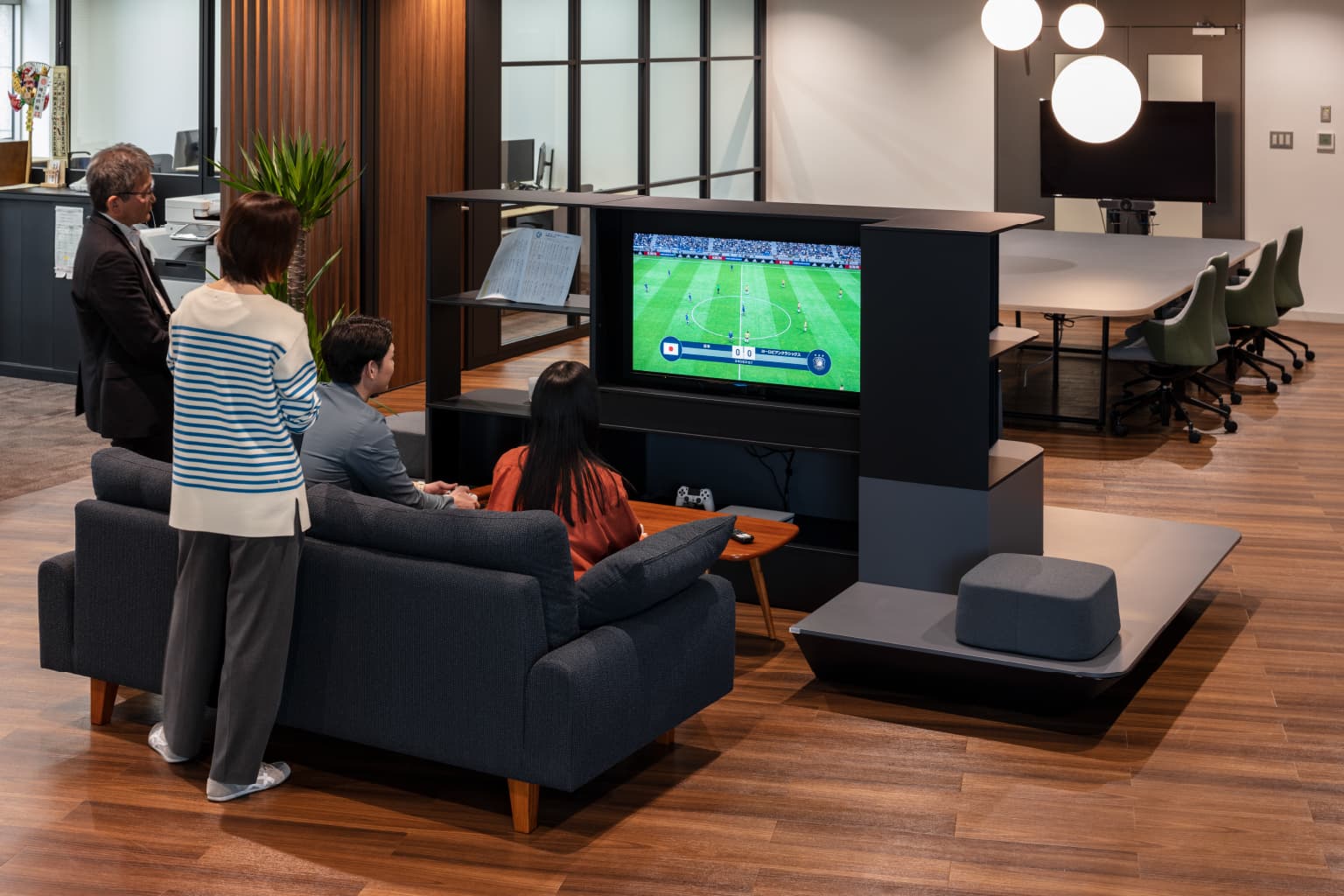 北電情報システムサービス株式会社 様の事例写真／[カフェエリア]縁側のようなスペース（WORK VILLA）の裏手には、ローテーブルとソファセットが置かれています。就業後にはソファに座って、シェルフに設置されたテレビでe-Sportsを楽しむ社員たちの姿も。