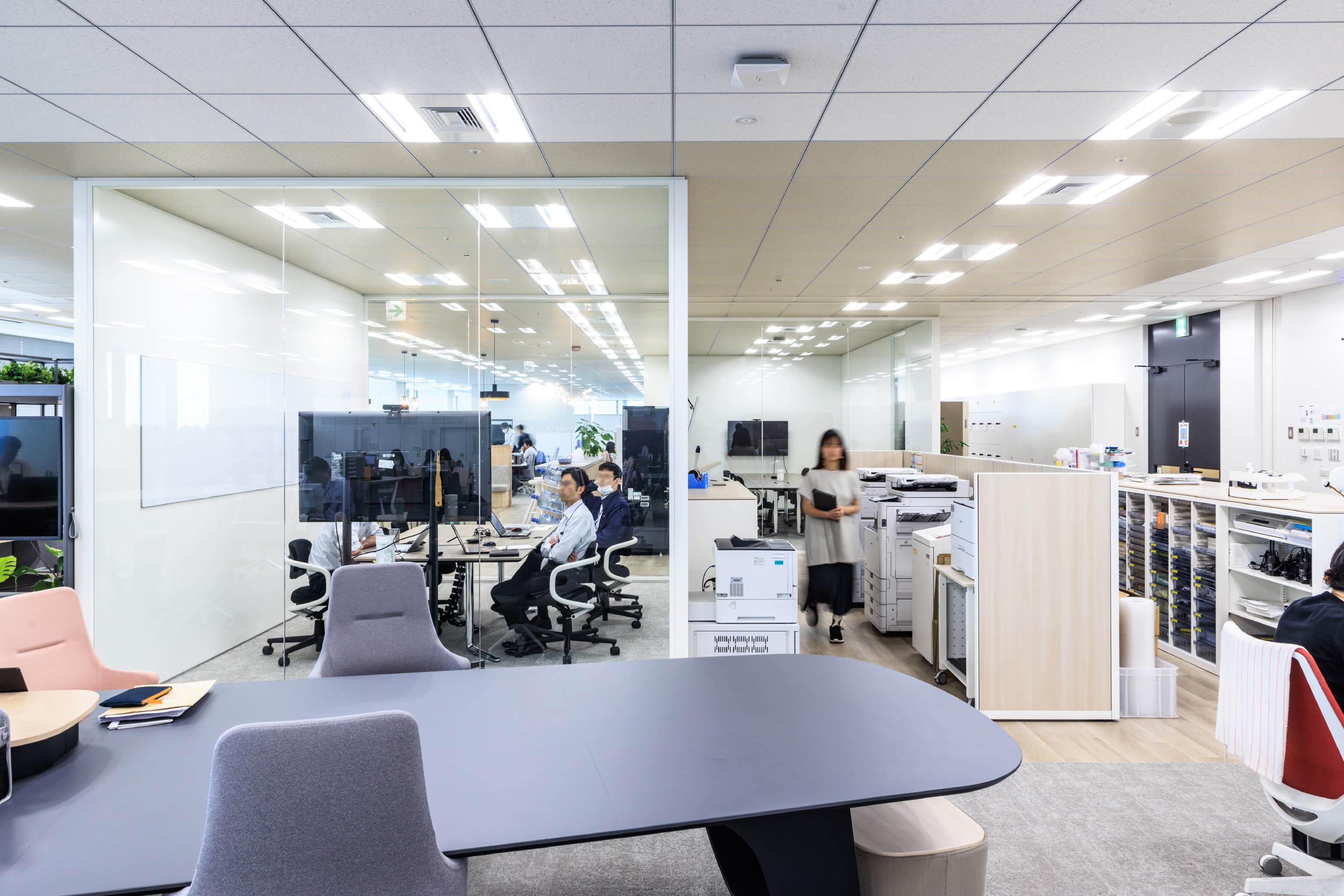 関西ペイント株式会社 様の事例写真／[社内会議室]執務エリアの中間には、二面がガラス張りになった会議室があります。ガラス張りによって執務エリアの見通しがよくなるほか、活発な会議の様子は会議室外の従業員の刺激にもなります。