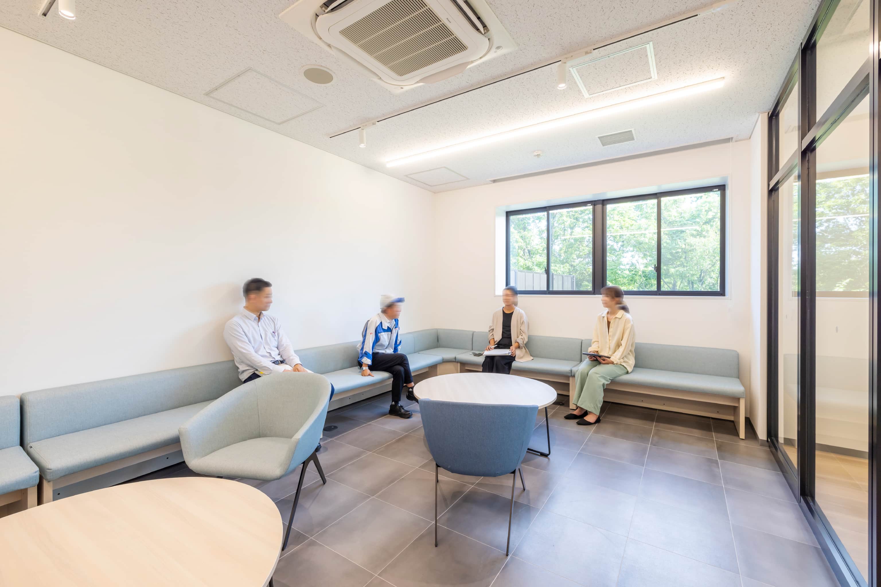 トヨタ車体株式会社 いなべ工場 様の事例写真／[1階談話室]談話室はガラス張りで遮音性が高い個室に。上司と部下との対話や相談にも使用されています。約20人が入れるよう設計し、組（トヨタ車体における組織の最小単位）の打合せや誕生日会などの利用も想定しています。