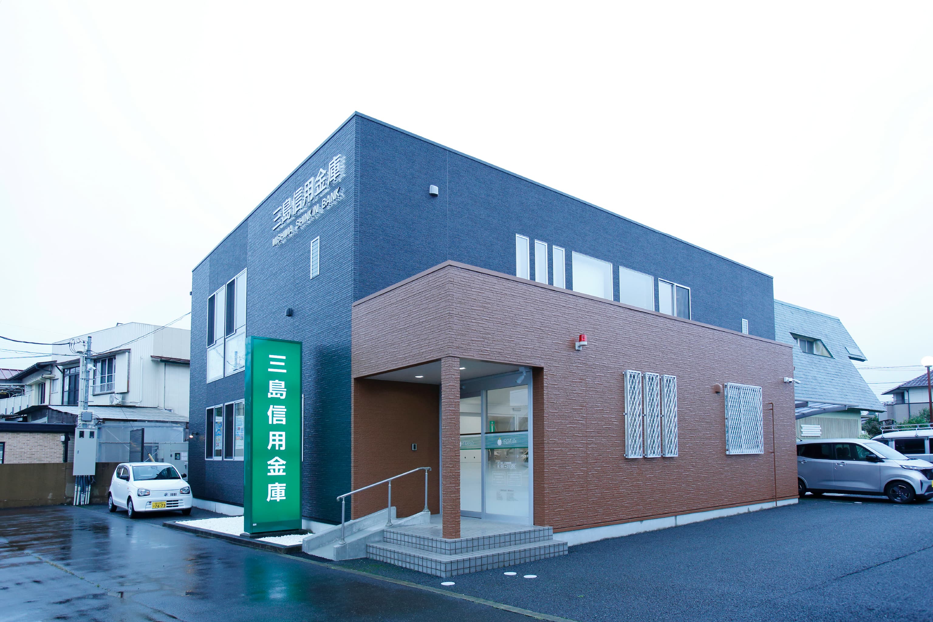 三島信用金庫 様の事例写真／[外観]黒で塗られた外壁が、おしゃれで洗練された印象をプラス。コーポレートカラーの緑色が映えています。富士山のふもとにあり、雨や霧の日が多い御殿場市でも汚れが目立ちにくく、かつ景観を損なわない外観です。