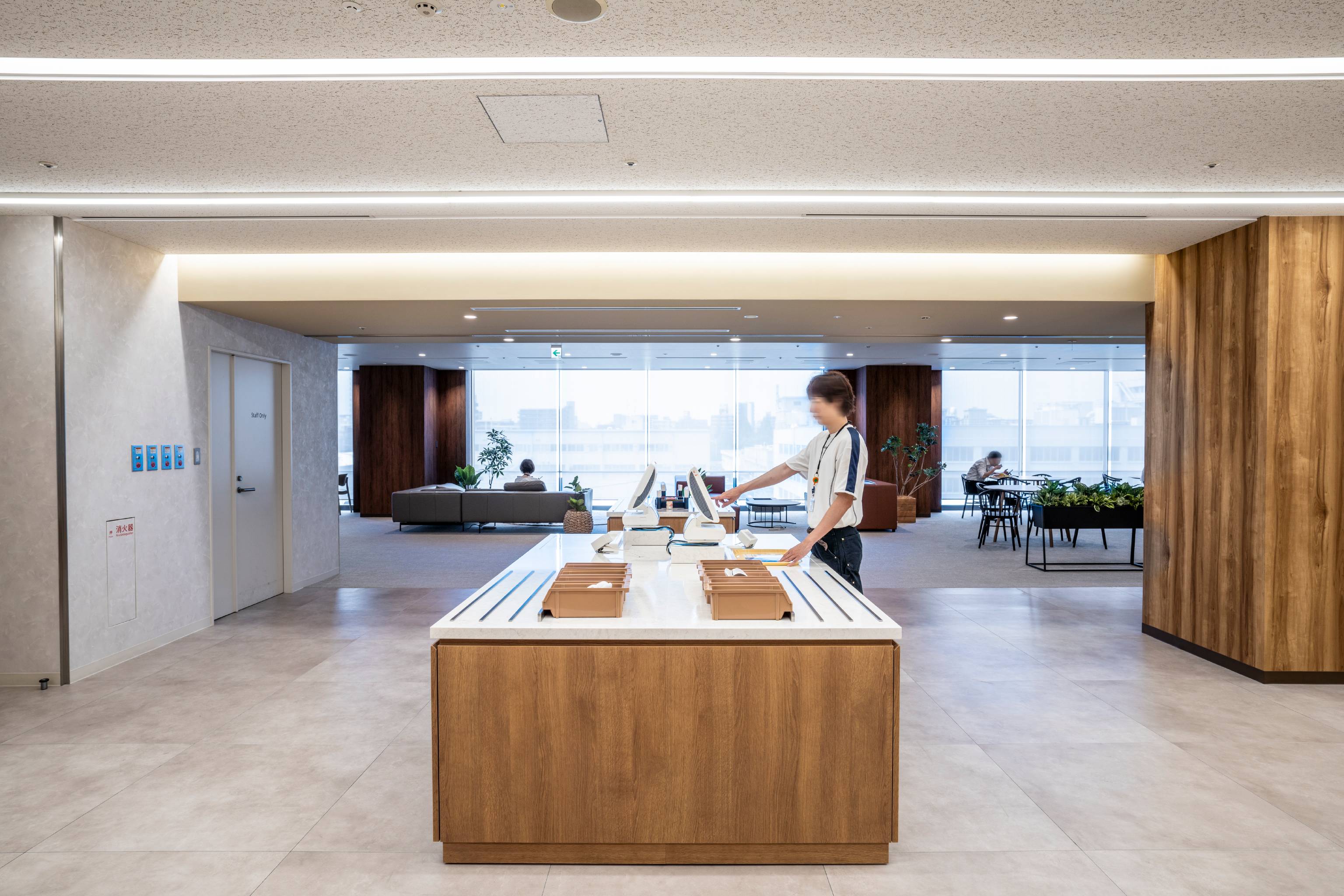 NEC （日本電気株式会社） 様の事例写真／[北棟 セルフ会計ゾーン]食器にはICチップが組み込まれ、レジに置くだけで会計に進むことができます。テクノロジーの利便性と、台にあしらわれた木のぬくもりという対照的な2つの要素が融合するユニークなゾーンです。