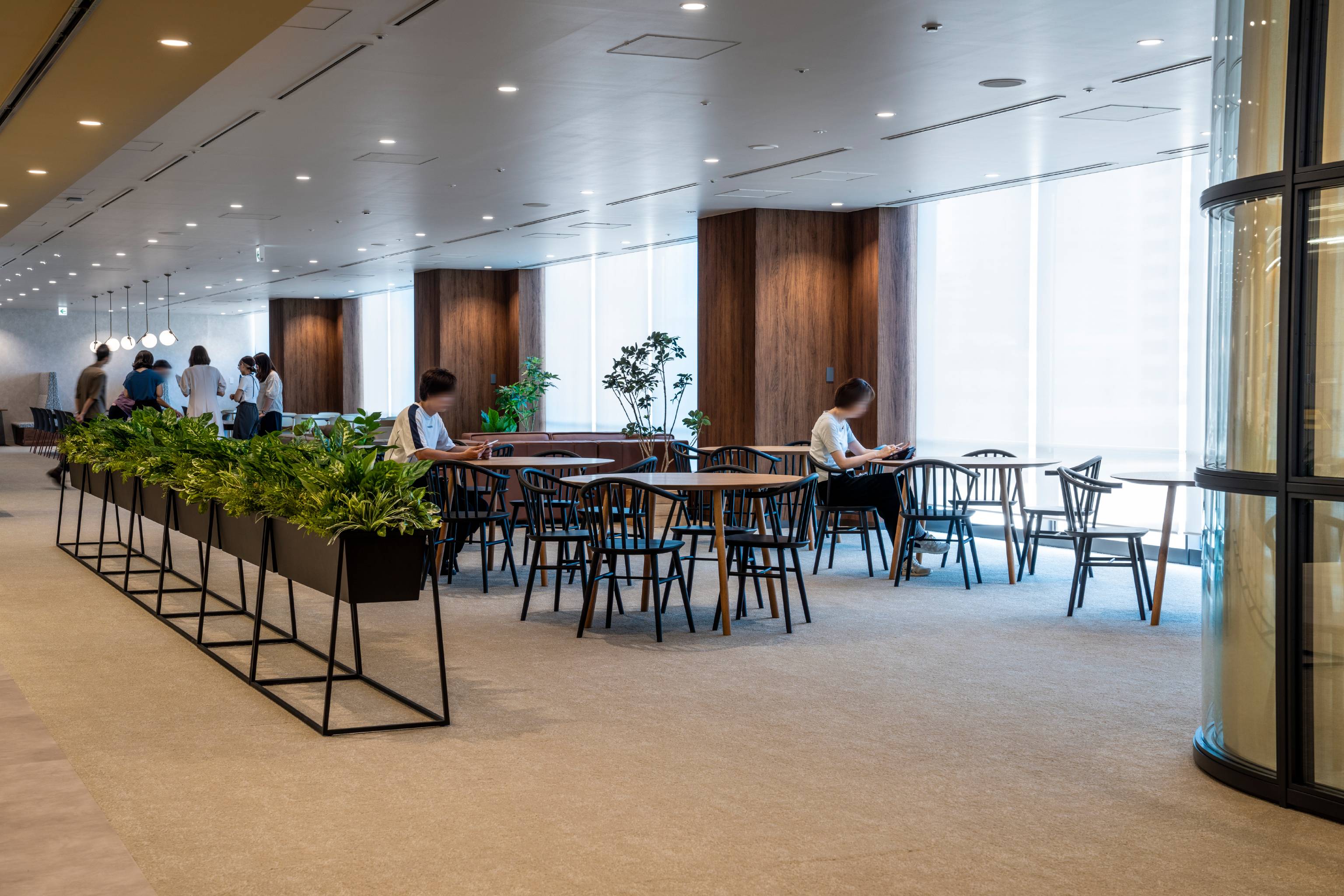 NEC （日本電気株式会社） 様の事例写真／[北棟 喫食エリア]社員食堂には珍しいカーペット敷きに加えて、シックな色合いのテーブルと椅子が配置され、落ち着きのある空間に仕上げられています。上質な設えの中で、ゆったりと過ごすことができます。