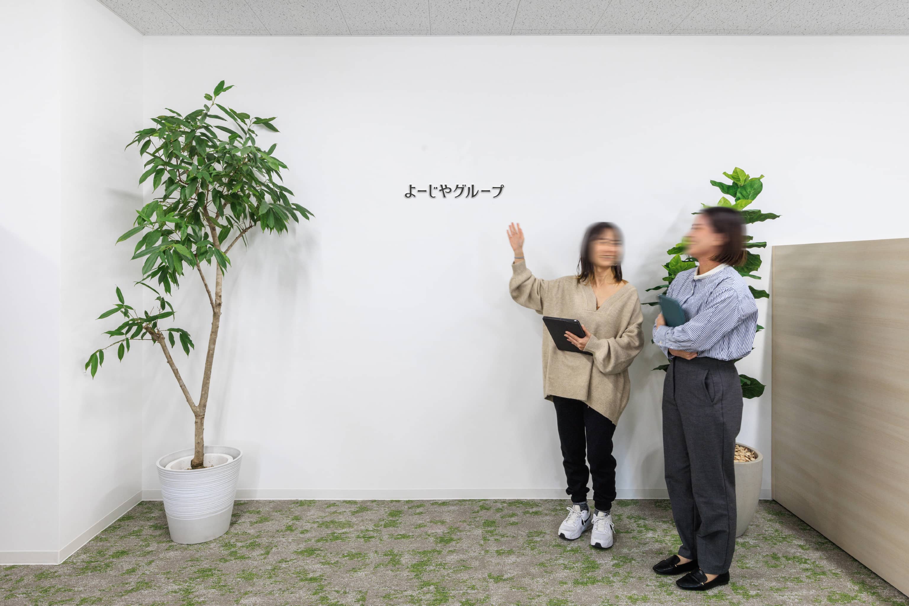株式会社よーじや 様の事例写真／[ブランディングウォール（執務エリア）]執務エリア内にある、ブランディングウォール。メディアの取材を受ける際に撮影場所となる、社を代表する大切な場所です。ロゴの位置は、取材対応が多い社長の身長とバランスのとれた高さに設定されています。