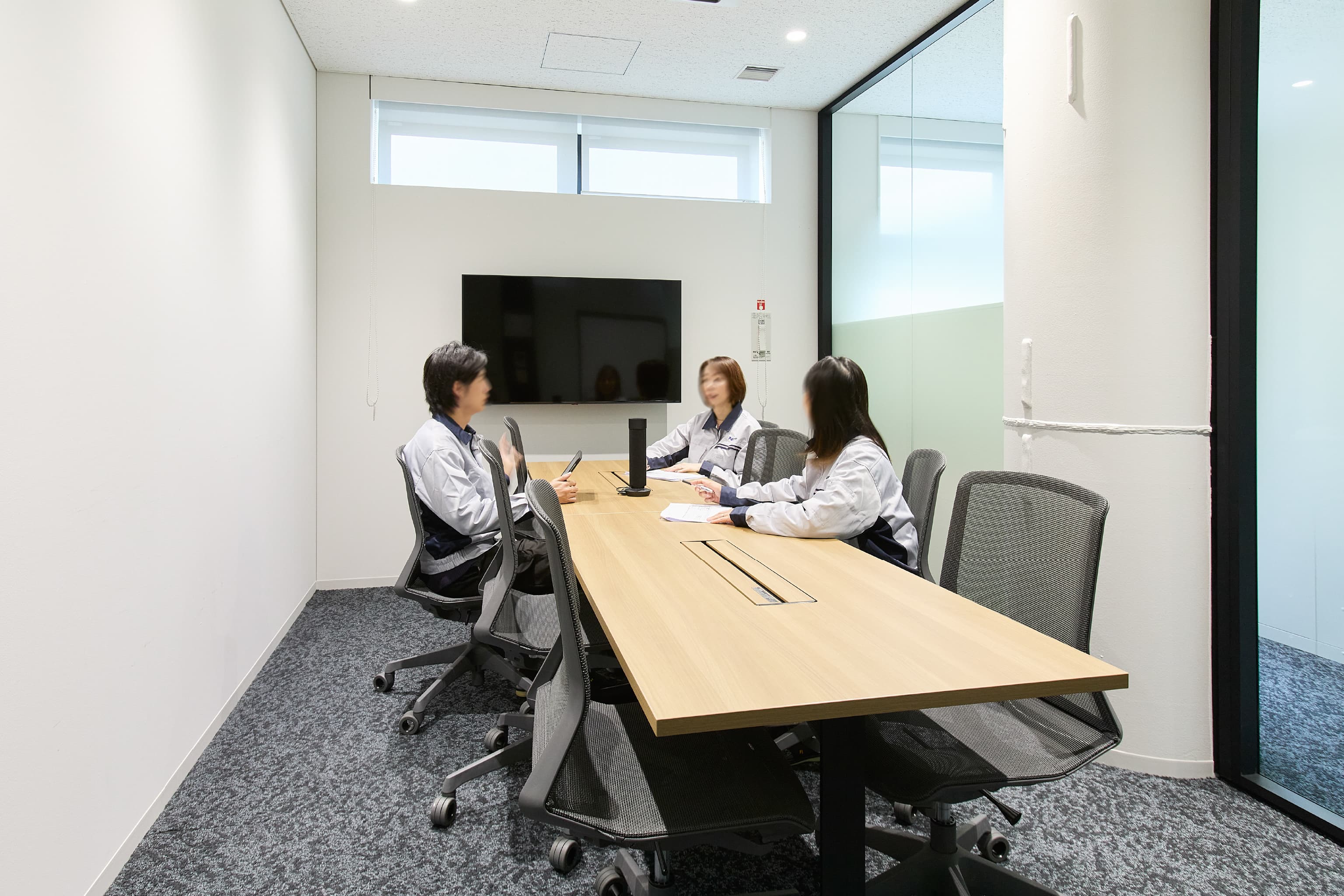 日東電工株式会社 様の事例写真／[5F 会議室]モニター完備の会議室。移動が簡単なキャスター付きのイスが、各室色違いで配置してあります。外から陽光が差し込む明るい会議室では、活発な意見が交わされています。