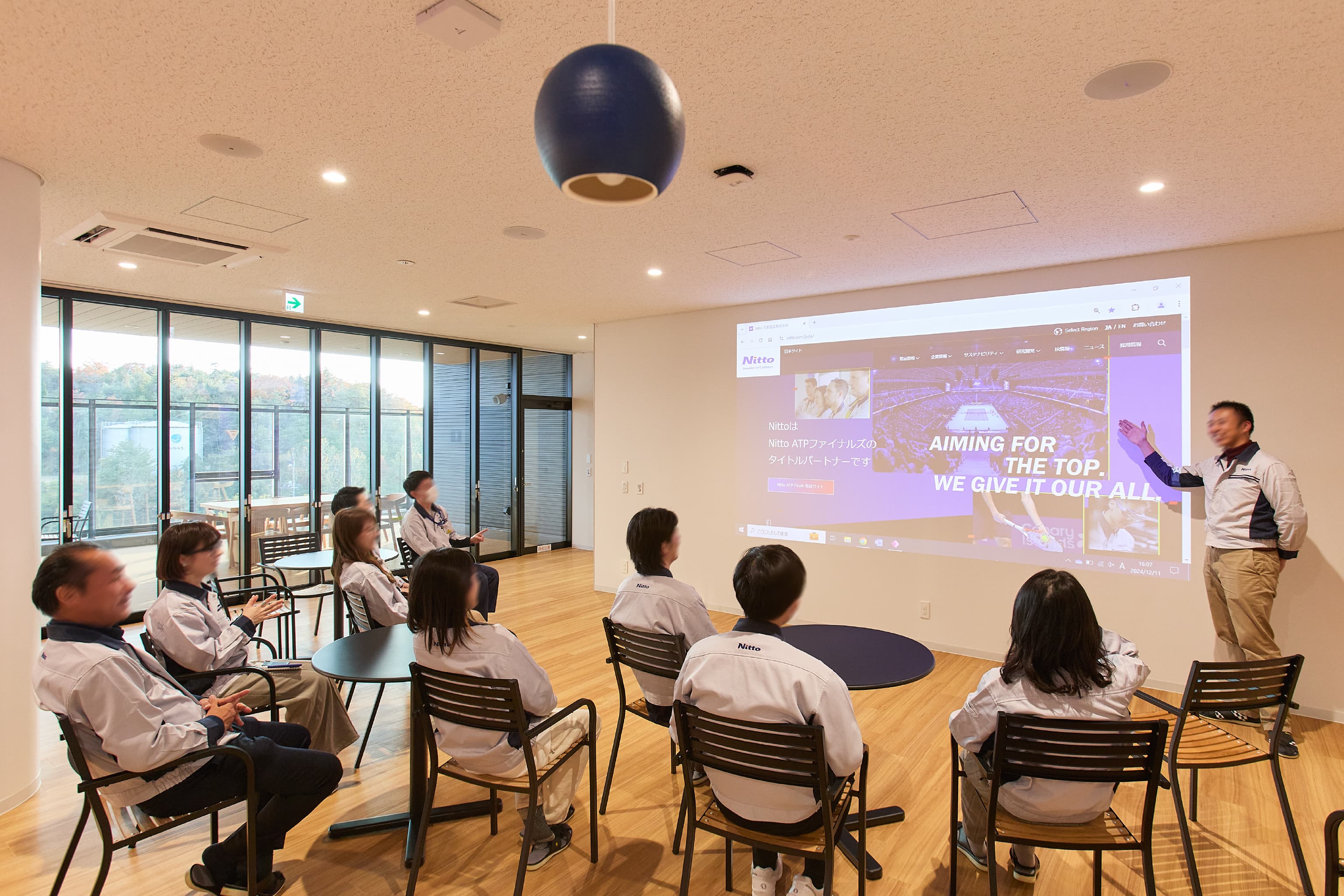 日東電工株式会社 様の事例写真／[6F 休憩スペース]白い壁はプロジェクターを投影するスクリーンになり、大人数でのミーティングやパーティー等にも利用可能です。