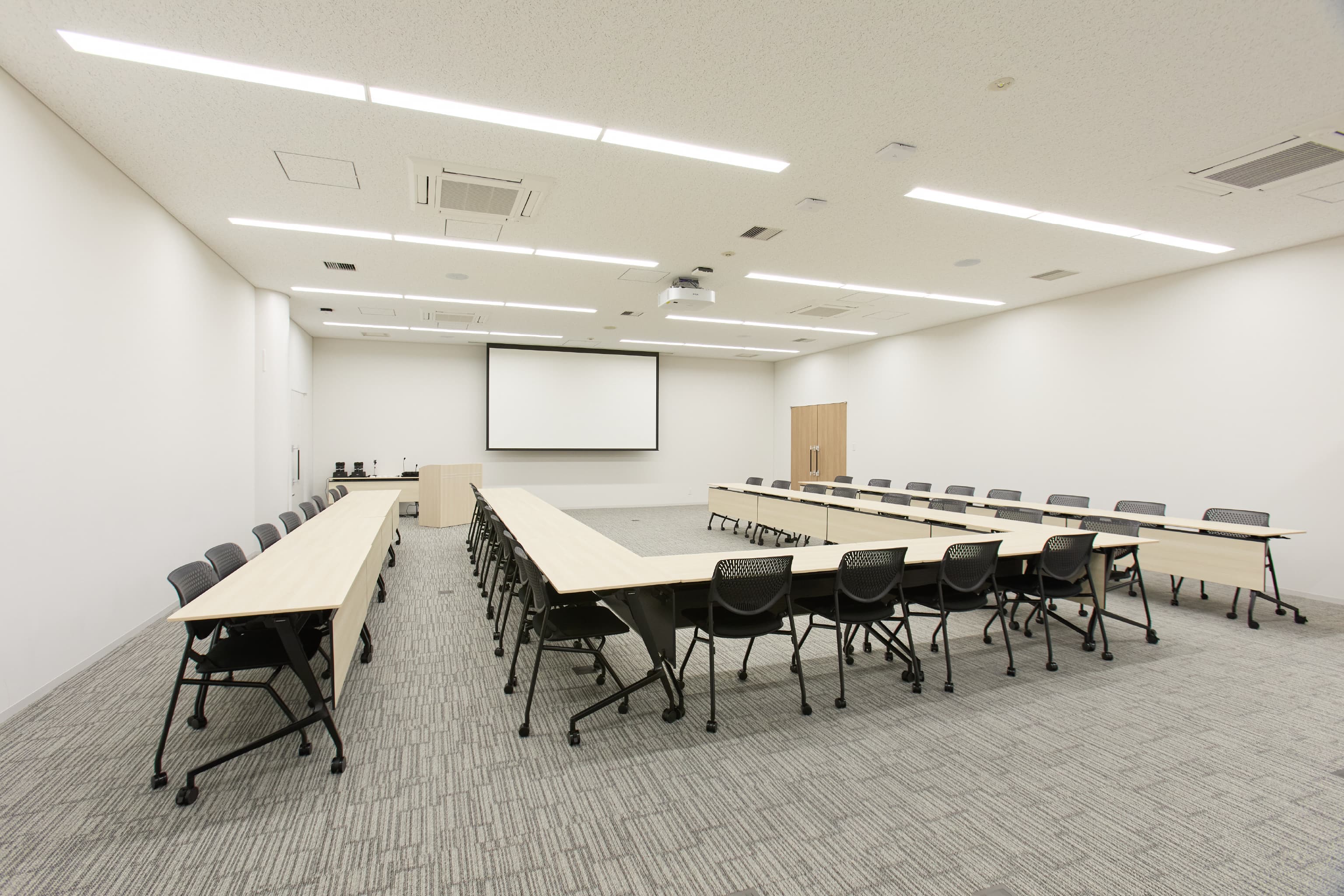 日東電工株式会社 様の事例写真／[6F 大会議室]6階にある大会議室は36人収容可能で、大型スクリーンとプロジェクター完備。定例会や社員研修などに利用されます。スライディングウォールを動かして、隣の会議室と連結させれば、さらに大人数で利用できます。