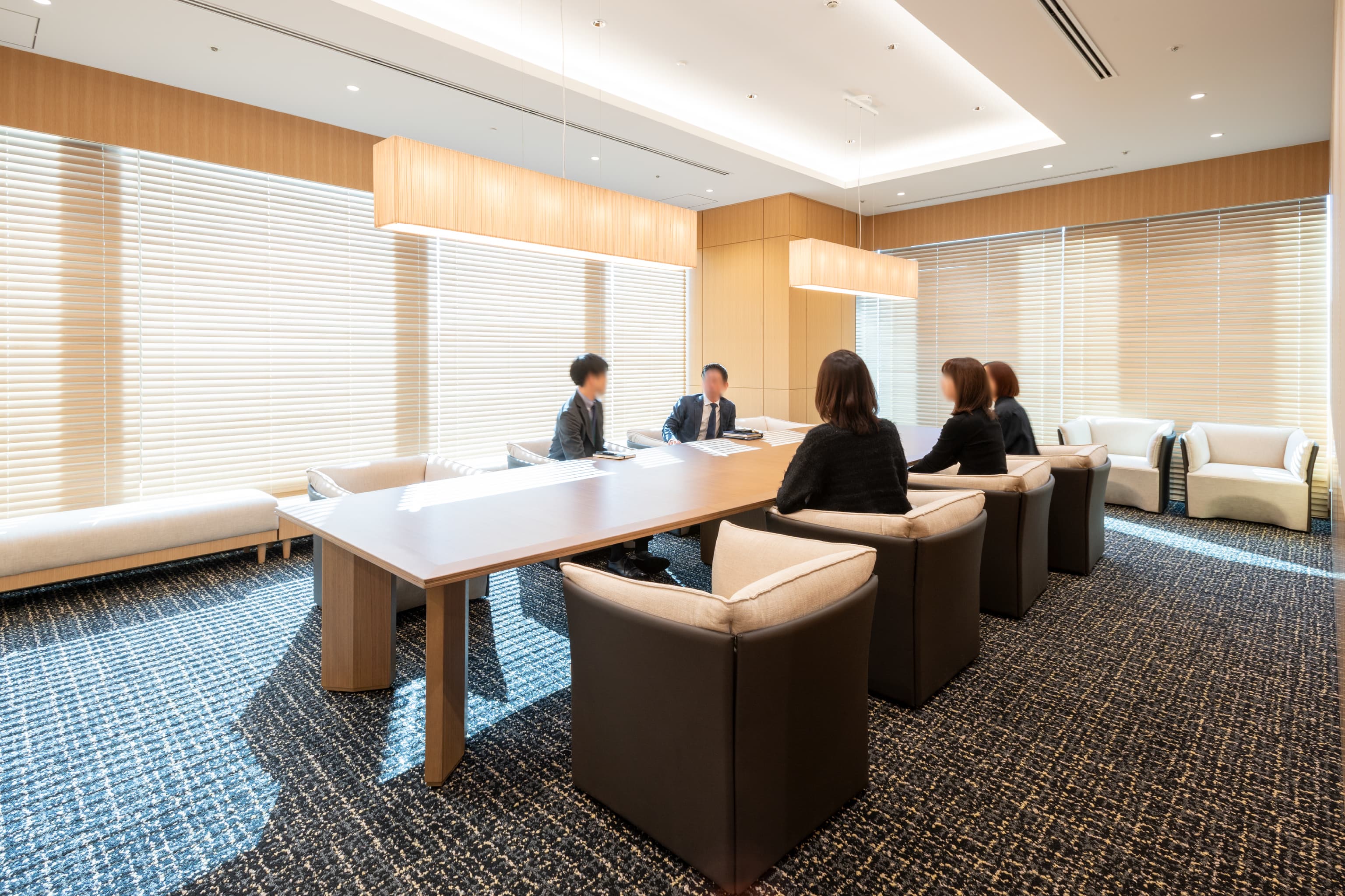 ハニューフーズ株式会社 様の事例写真／[特別応接室]テーブルや椅子、照明に至るまで上質な素材が採用され、国産木のブラインドと相まって格調高い雰囲気を醸成。二面の窓からはたっぷりと自然光が降り注ぎ、開放感と落ち着きを兼ね備えた空間に仕上げられています。