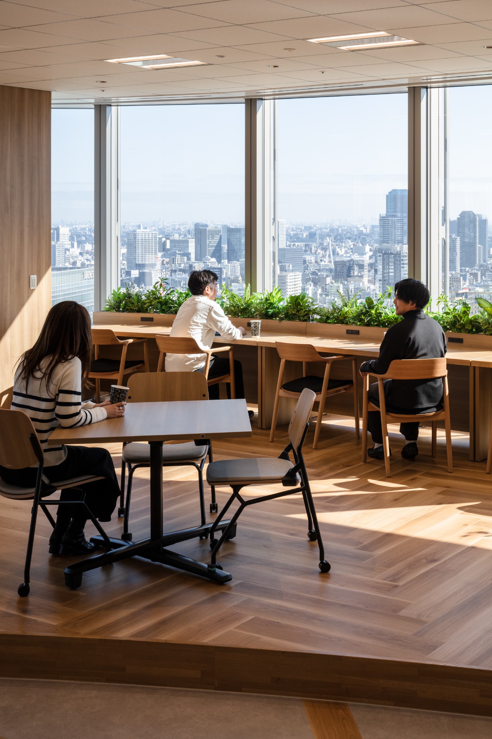 旭化成株式会社 様の事例写真／[社員食堂『BLANCA』]眺めが良い窓際の席は、特に人気が高い場所。柔らかな陽の光に包まれながら、好きなドリンクを楽しむ心地よいひとときが、次の仕事への意欲を高めてくれるでしょう。