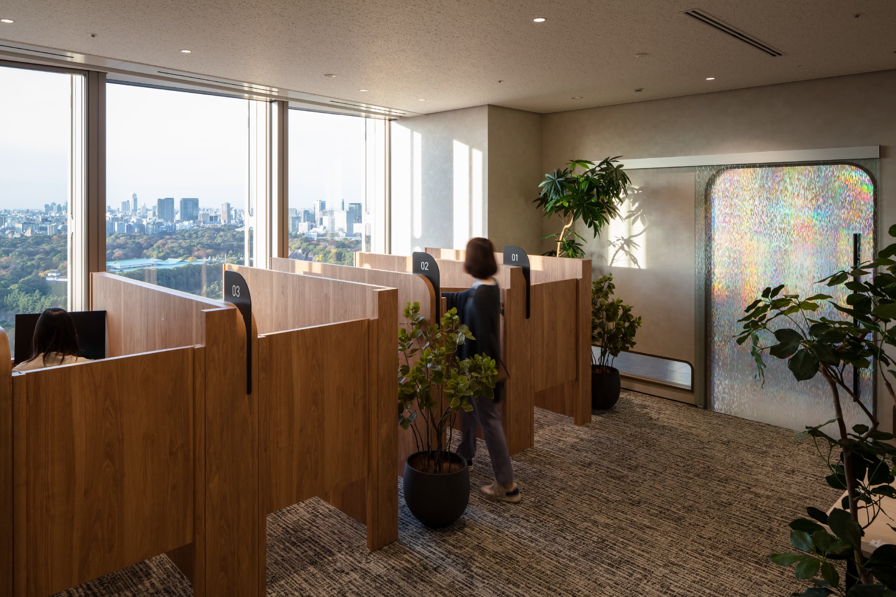 旭化成株式会社 様の事例写真／[高集中ルーム]ワークスペースとは扉で仕切られた、集中のための独立空間。作業ブースも壁で区切られ、没頭できる環境です。入り口の扉には虹色の光がきらめき、印象的なアクセントに。プリズムのテーマが細部にまで息づいています。
