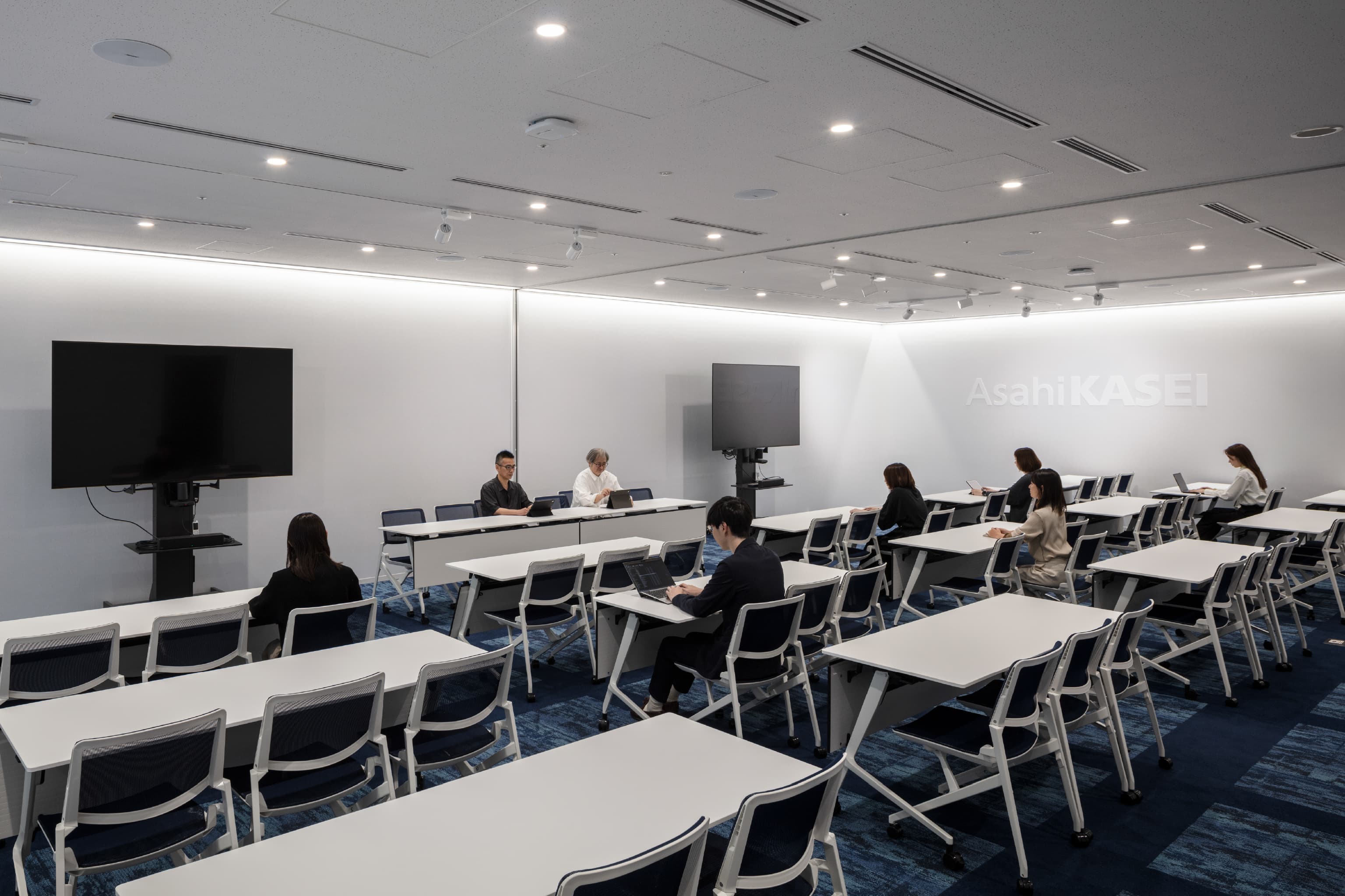 旭化成株式会社 様の事例写真／[プレゼンテーションルーム]最大78席を備え、大規模な会議や記者会見、決算発表の場として利用されています。青を基調としたカーペットは大海原を思わせ、次の100年へ向けた力強い航海をイメージさせます。