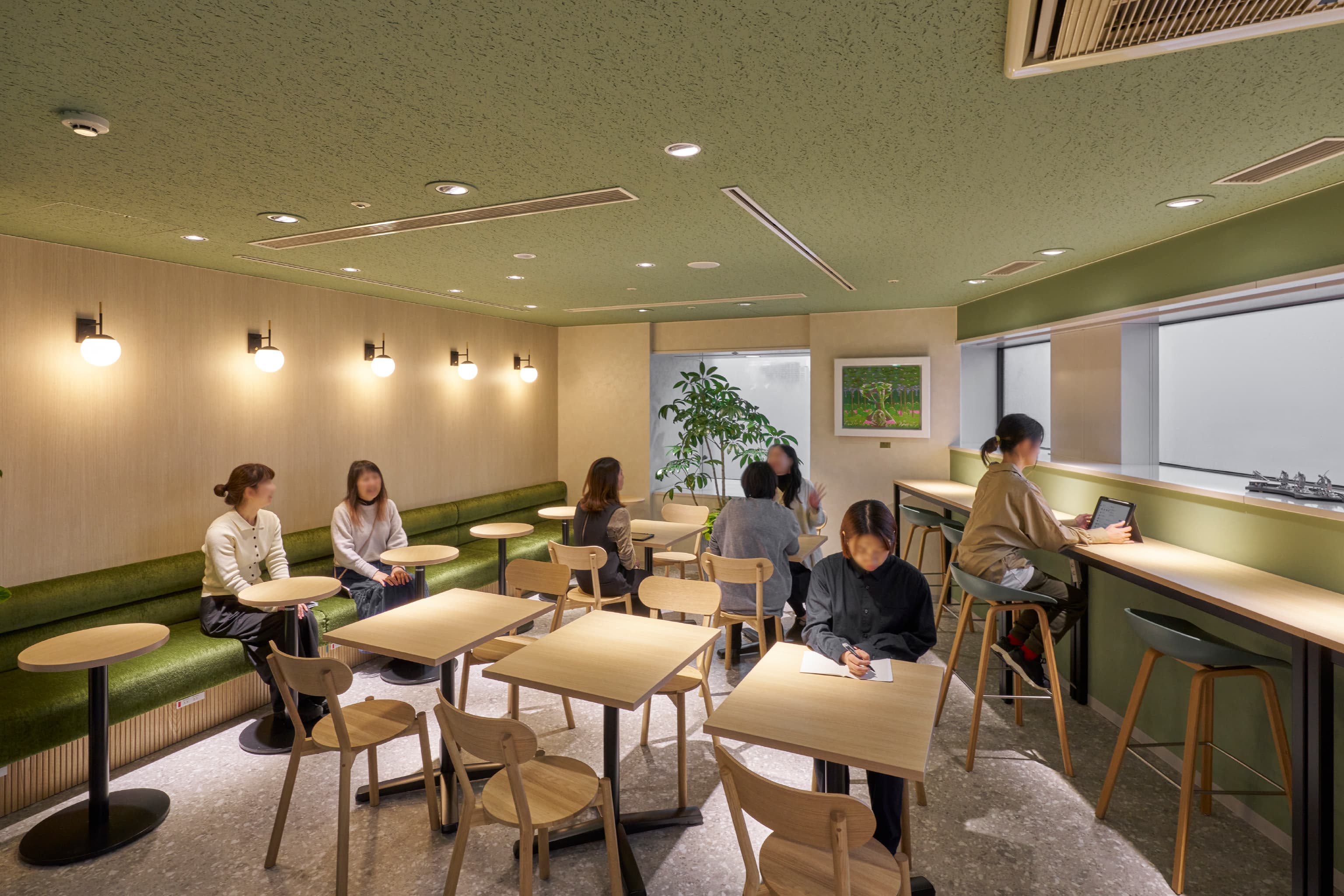 株式会社JALナビア 様の事例写真／[リフレッシュエリア]グリーンを基調とした癒しの空間が広がる北側のリフレッシュエリアは、１人や2人で使える席が中心です。什器は南側と同じフォルムで統一感を持たせつつ、違う配色に。南側とイメージが異なるので、その日の気分に合わせて使い分けができます。