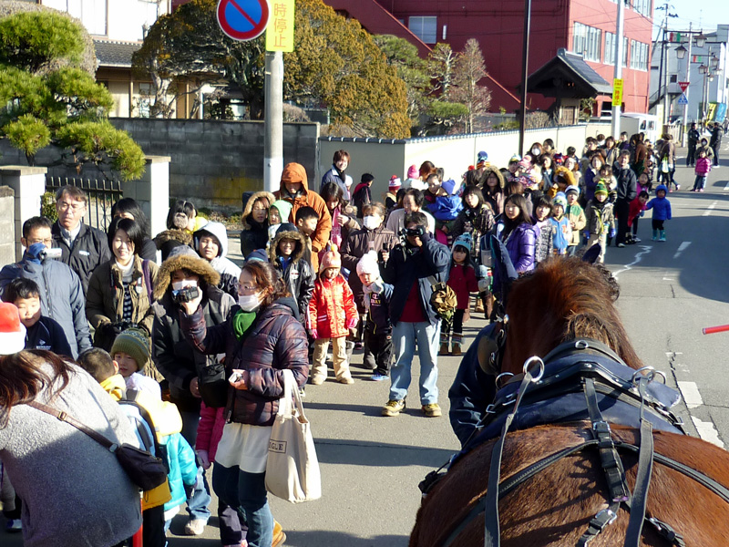 クリスマス馬車。沿道にはたくさんの人々が集まった