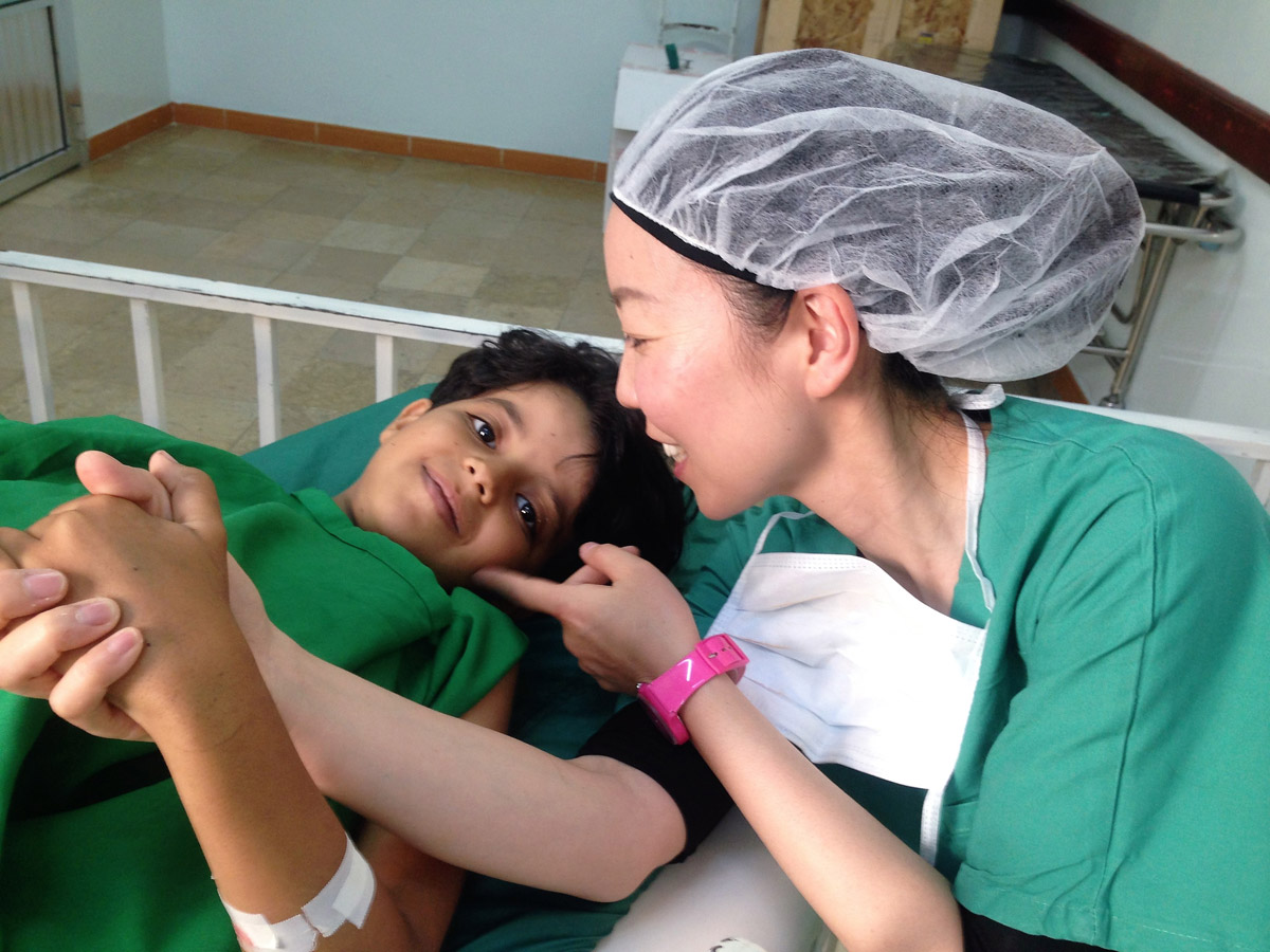 子どもの手を握って思いを伝える白川さん。2016年イエメンにて(©MSF)