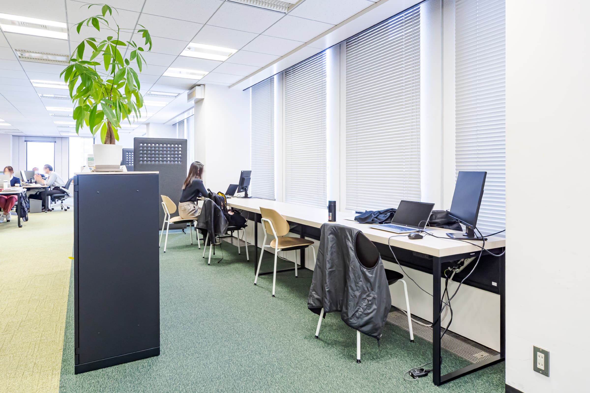 オフィスエリア　窓際スペース／執務スペースとの境界に収納を設置することで、緩やかに区切られており、個人の集中作業に最適。　