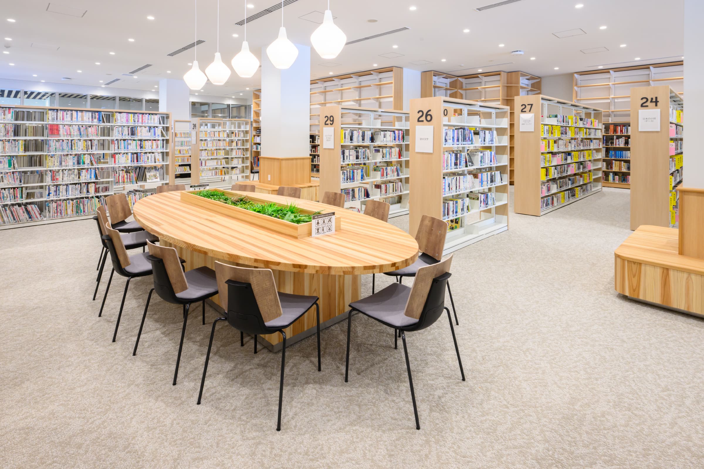 図書館／大型テーブル・柱巻きベンチは建築工事にて対応。木のぬくもりが感じられ、温かみを感じられる。