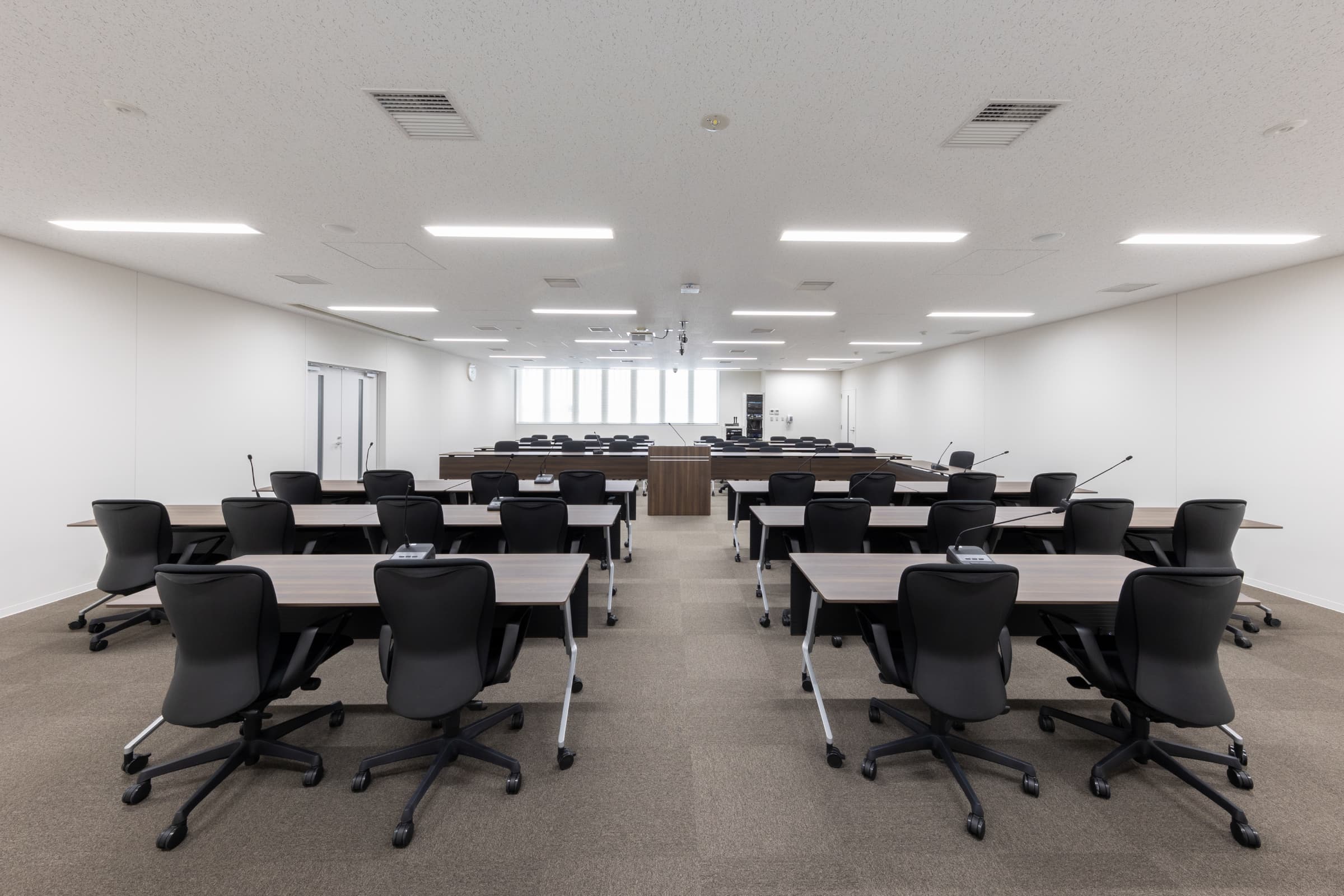 全員協議会室(54席）／各種資料が広げやすいよう、1人当たりW900D600サイズの会議テーブルを配置。天板は抗菌・手痕がつきにくくふき取りやすい面材を使用。