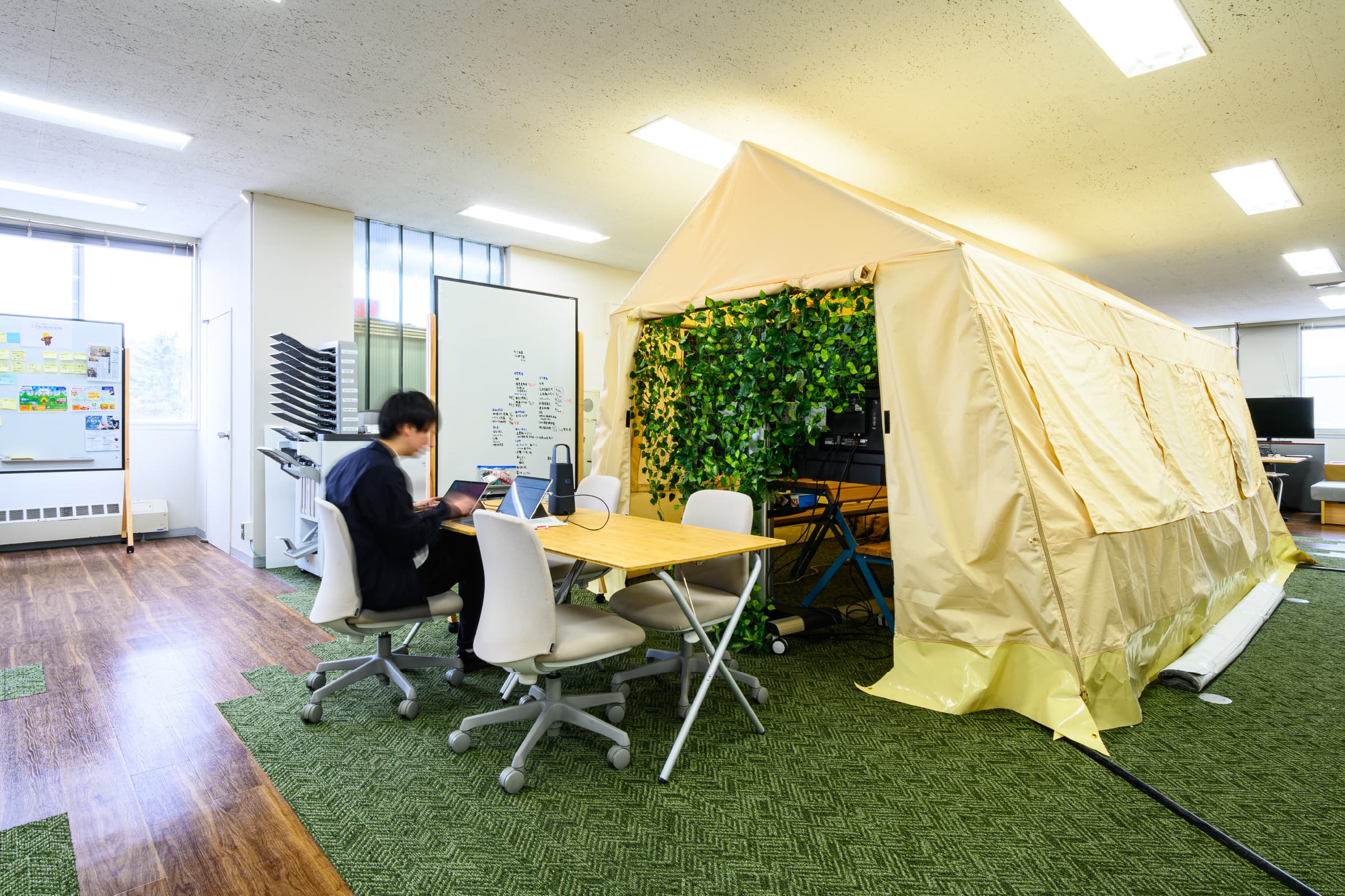 テントスペース／執務室中央部に配置し、オフィスの象徴ともいえるテントスペース。通常オフィスにはない設えを採用することで、柔軟な発想を促し、職員のモチベーションアップにつなげている。