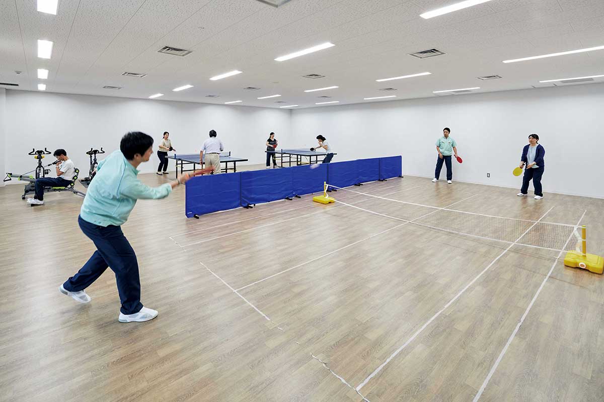 2行目：4Fのアスレチックルームには、卓球やフリーテニス（テニス＋ピンポンの融合スポーツ）、トレーニングなどを楽しめる設備と環境が整えられている。昼休みに試合が白熱することも。