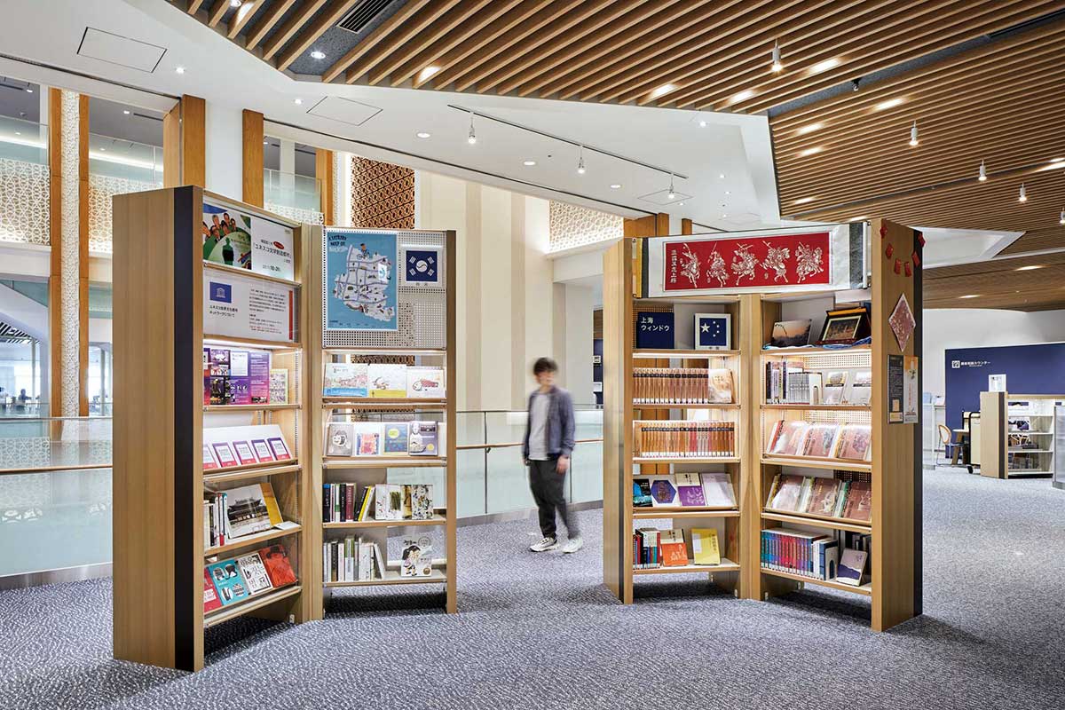 1行目：4階吹き抜けまわりに設けられた「多文化エリア」。国内では入手しづらい米国や中国、韓国の本を借りることもできる。