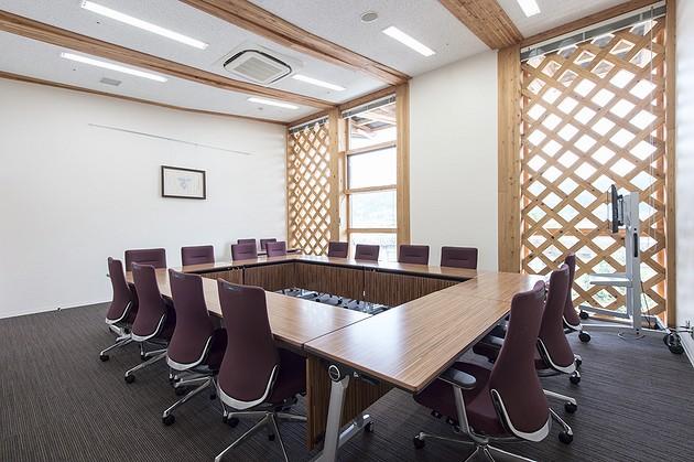 2F庁議室／ダーク系の木目テーブルを配置した重厚な空間。